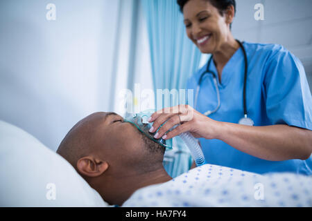 Krankenschwester Anpassung Sauerstoffmaske auf Patienten Mund Stockfoto