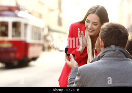 Vintage Heiratsantrag im Freien in den Straßen von Portugal mit einer roten Straßenbahn im Hintergrund Stockfoto