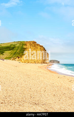 Ein steiler Pfad steigt vom relativ flachen Sand durch grüne Vegetation an die Spitze der vertikalen East Cliff in Bridport Sands Stockfoto