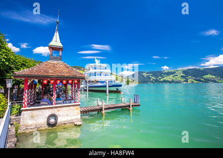 Malerischen Panoramablick auf traditionellen Ausflug Schiff am berühmten Zuger See an einem sonnigen Tag mit blauem Himmel und Schweizer Alpen Stockfoto