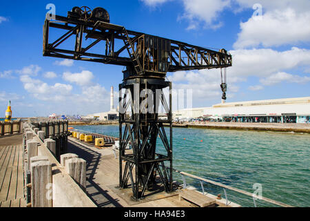 TEL-AVIV - 25. Juli 2014: Einen restaurierten alten Kran, mit Restaurants und Einkaufszentrum im Hintergrund, im Hafen von Tel-Aviv, Israel. Der Hafen zusammengesetzte wa Stockfoto