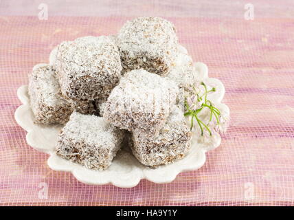 köstliche Lamingtons auf einem weißen Teller Stockfoto