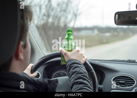 Junger Mann mit seinem Auto beim trinken Alkohol Stockfoto