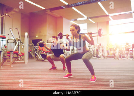 junger Mann und Frau mit Langhantel im Fitness-Studio trainieren Stockfoto