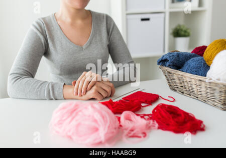 Frau mit Stricknadeln und Garn im Korb Stockfoto