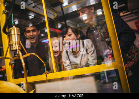 Junge Freunde spielen Spielzeug greifen Spiel im Freizeitpark begeistert. Glückliche Frau eine zufällige Stofftier in einem Automaten auswählen. Stockfoto