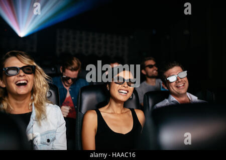 Gruppe von jungen Freunden 3d Film im Theater und lachen. Junge Männer und Frauen mit 3d Brille im Kinosaal. Stockfoto