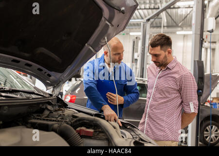 Automechaniker mit Zwischenablage und Mann an dem Auto Shop Stockfoto