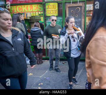 Zahlreiche Besucher auf den Bryant Park Holiday Markt Line-up am Kiosk Pickle mich Pete um sich bei einer Abnahmemenge von gebratenen Gurken, gesehen auf Samstag, 19. November 2016 zu stillen.  (© Richard B. Levine) Stockfoto