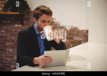 Mit digitalen Tablet während Kaffee Geschäftsmann Stockfoto