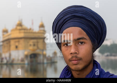 Ein Junge Sikh-Pilger vor The Golden Temple Complex in der Sikh Stadt Amritsar, Punjab, Nordindien Stockfoto