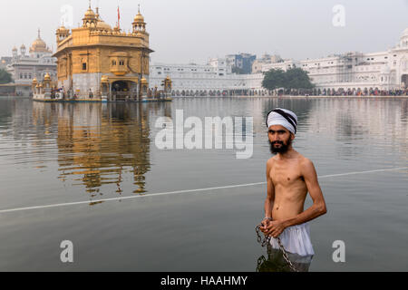 Golden Temple, Hari Mandir, ein Pilger mit Turban, wobei ein rituelles Bad im Heiligen See von Amritsar, Punjab, Indien Stockfoto