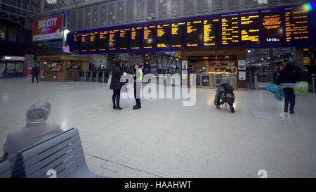 Familie in Glasgow Hauptbahnhof Bahnhof telefonieren suchen Ankünfte board Stockfoto