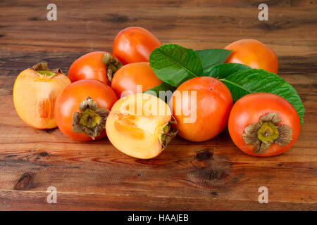 Persimone. Kaki Früchte auf alten hölzernen Hintergrund. Stockfoto