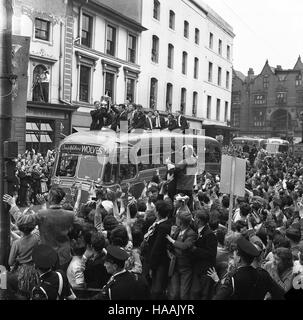 Massen von Menschen jubeln den FA-Pokalsiegern Wolverhampton Wanderers 1960 bei ihrer Rückkehr im Triumph durch die Straßen von Wolverhampton zu. Wölfe Kapitän Bill Slater hält den Pokal. Stockfoto