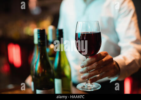 Barkeeper halten Glas Rotwein Stockfoto