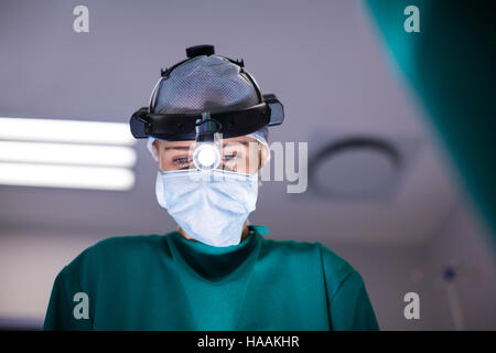 Weibliche Chirurg chirurgischen Lupen während Operation tragen Stockfoto