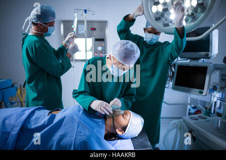 Chirurgen, die Anpassung der Sauerstoffmaske auf Patienten Mund im Betrieb theater Stockfoto