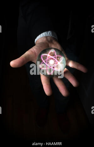 Atom hält in Fortune Teller magische Kristallkugel Stockfoto