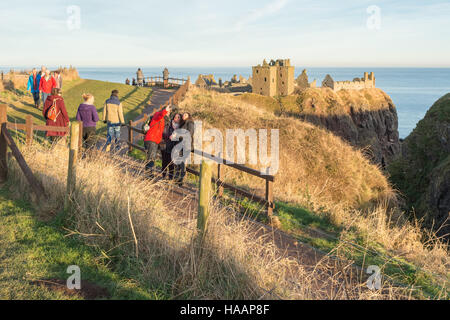 Dunnottar Castle, Stonehaven, Schottland - Besucher genießen den Winter Sonnenuntergang Stockfoto