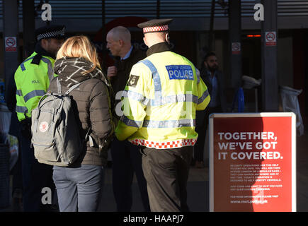 Ein Polizist spricht ein Pendler am Vauxhall Busbahnhof in Süd-London, um die Einführung des Anti-Terror-Patrouille Polizeieinheiten quer durch die Hauptstadt zu markieren. Stockfoto