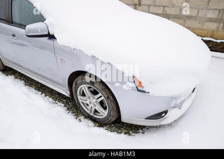 Fallen schlafend nassem Schnee Auto. Schneefall von nassem Schnee. Schnee liegt auf dem Auto. Stockfoto