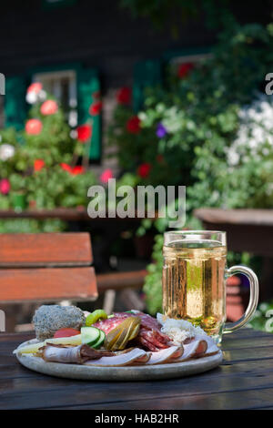 Brettljause - österreichische traditionelle Teller mit Aufschnitt mit Selfmade Inhaltsstoff auf alten Holztisch. Südsteiermark, Europa Stockfoto