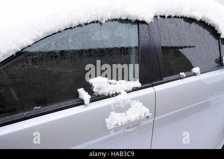 Fallen schlafend nassem Schnee Auto. Schneefall von nassem Schnee. Schnee liegt auf dem Auto. Stockfoto