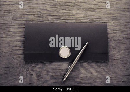 Umschlag mit Briefmarke und Stift auf dem Holztisch Stockfoto