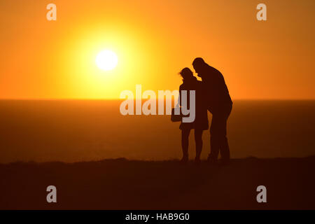 Beachey Kopf, East Sussex. 28. November 2016. Ein paar Peer über den Rand der berühmten Klippen in der Nähe von Beachy Head wie die Sonne setzt an einem sonnigen Tag Beautifuly. Bildnachweis: Peter Cripps / Alamy Live News Stockfoto