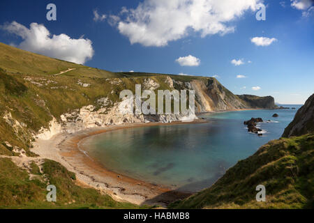 St. Oswald Bay und Mann o Krieg Felsen helle Wolken im blauen Himmel und Cliff Spiegelungen im Wasser - Dorset UK Stockfoto