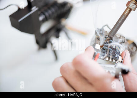 Nahaufnahme von mans Händen mit Chip und Lötkolben Stockfoto