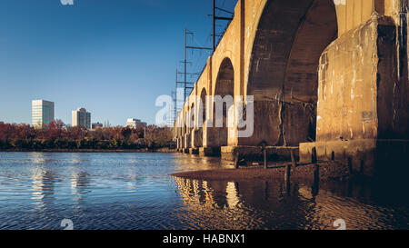 Über den Ufern des Raritan von New Brunswick, NJ, sitzt die Northeast Corridor Bahnlinie auf eine unbenannte Eisenbahnbrücke. Stockfoto