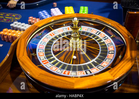 Hölzerne bunte Casino Roulette. Casino-Maschinen- und Glücksspiel. Roulette-Tisch mit Chips neben Roulette. Drehenden Roulette in Gang. Stockfoto