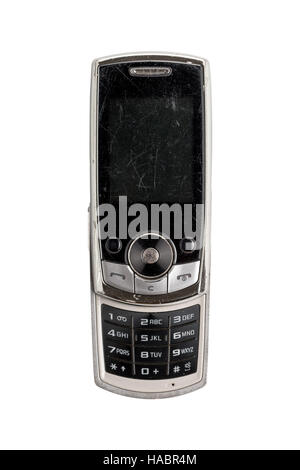 sehr alte verkratzte Handy, isoliert auf weiss Stockfoto