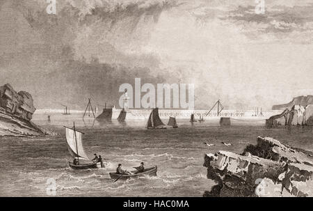 19. Jahrhundert-Blick auf den neuen Leuchtturm und Kais in Dunmore East. Entworfen von Alexander Nimmo, die Royal Mail-Schiffe zu erleichtern.  County Waterford, Irland Stockfoto