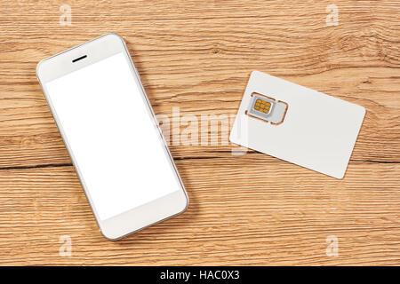Smartphone mit leeren Bildschirm und Handy GSM-SIM-Karte auf dem Tisch, Ansicht von oben Stockfoto