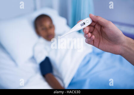 Hand der Krankenschwester mit Thermometer im Bezirk Stockfoto