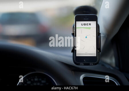 Das Innere der ein Uber Taxi mit einem iPhone zu Windschutzscheibe des Autos mit dem Firmenlogo. Stockfoto