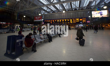 Familie in Glasgow Hauptbahnhof Bahnhof telefonieren suchen Ankünfte board Stockfoto