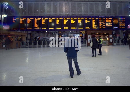 Familie in Glasgow Hauptbahnhof Bahnhof telefonieren suchen Ankünfte board Stockfoto