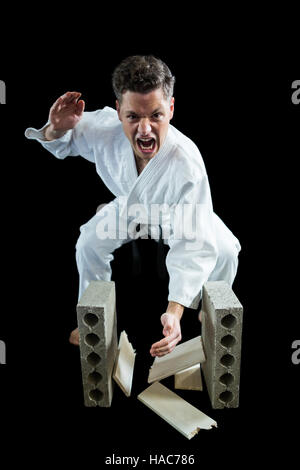 Karate Spieler brechen Holzbrett Stockfoto