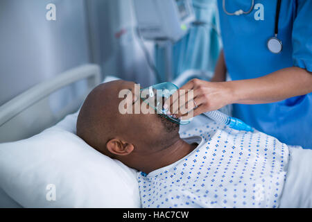 Krankenschwester Anpassung Sauerstoffmaske auf Patienten Mund Stockfoto