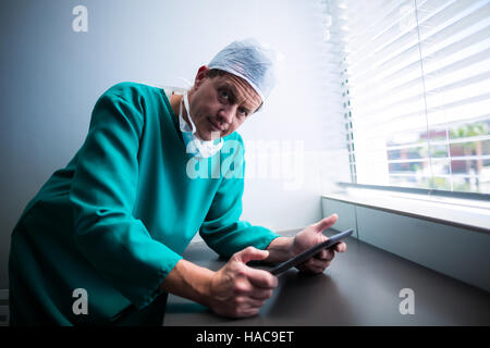 Porträt des männlichen Chirurgen mit digital-Tablette am Fenster Stockfoto