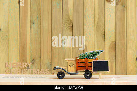 Spielzeug-LKW trägt Geschenke und einen Weihnachtsbaum. Weihnachten Hintergrund Stockfoto