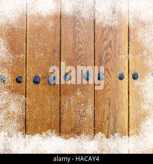 Winter Hintergrund mit Schneefall auf den alten hölzernen Scheune Wand und Schneeverwehung Stockfoto