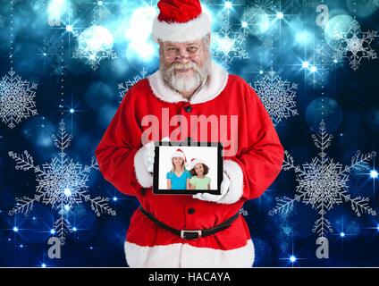 Santa Claus holding eine digitale Tafel mit Foto von Weihnachten Kinder Stockfoto