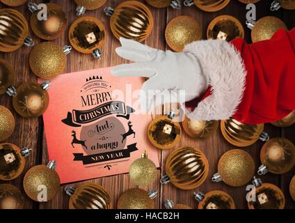 Santa Claus Holding Christbaumkugel mit Gruß zu Weihnachten im Hintergrund Stockfoto