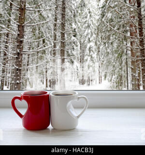 Zwei Tassen Kaffee auf der Fensterbank. Im Hintergrund, einem wunderschönen Winterwald im Schnee Stockfoto