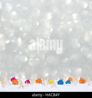 Weihnachten-Bokeh-Hintergrund mit kleinen Holzhäusern, Weihnachtsbäume und Schnee Stockfoto